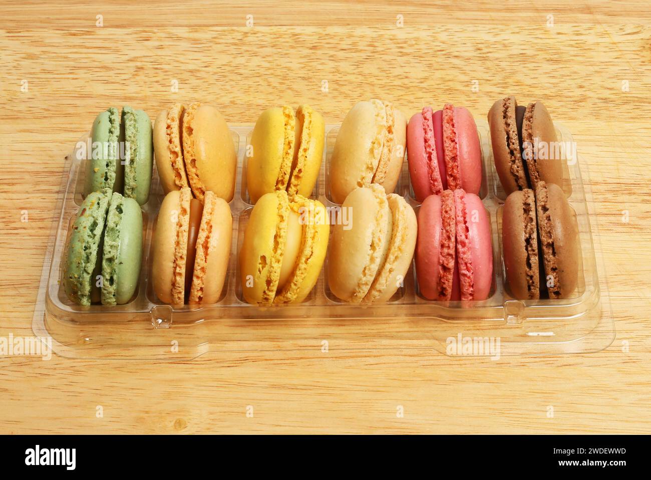 Auswahl von Macarons in einem Tablett auf einem Holzbrett Stockfoto