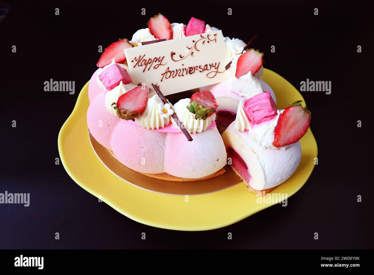 Wunderschöner Erdbeergelee Vanillemousse-Jahrestag-Kuchen auf schwarzem Hintergrund Stockfoto