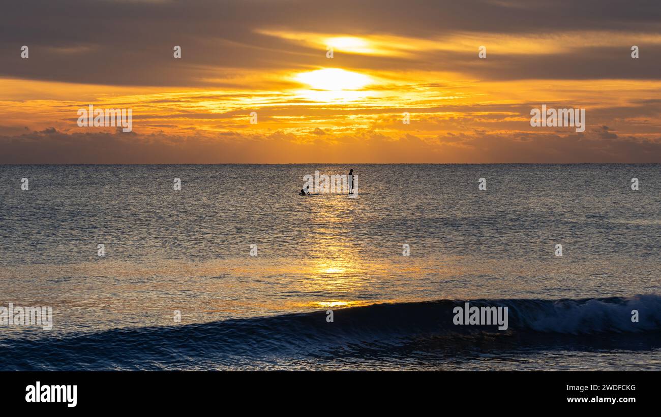 Paddleboarder auf dem Meer bei einem fesselnden Sonnenaufgang, perfekt für Adventure Sport Marketing, Lifestyle Editorials und Reise Inspiration. Stockfoto