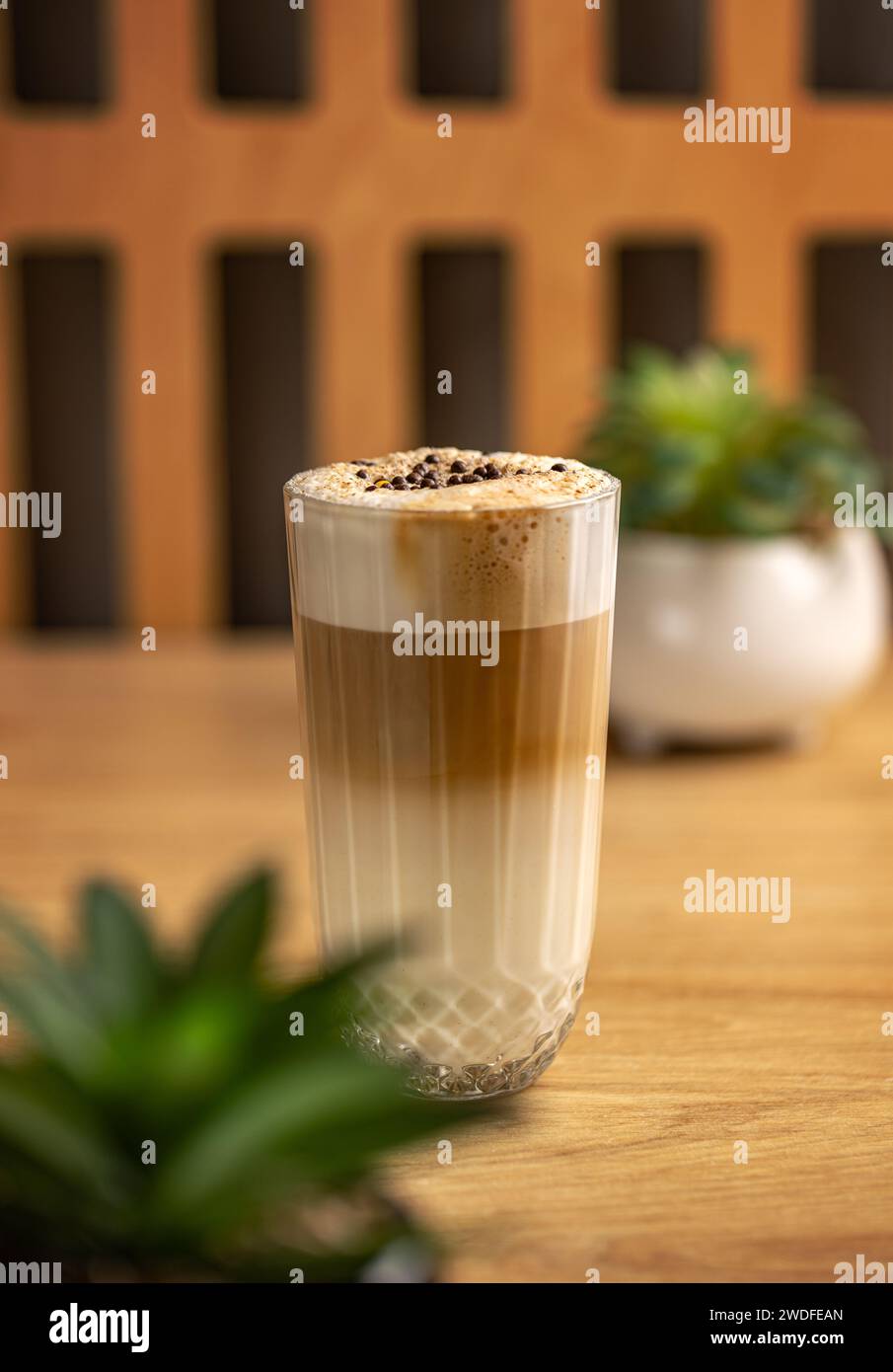 Glas mit köstlichem heißem Latte Macchiato, mehrschichtigem Kaffee in einer durchsichtigen Glaskaffeetasse. Stockfoto