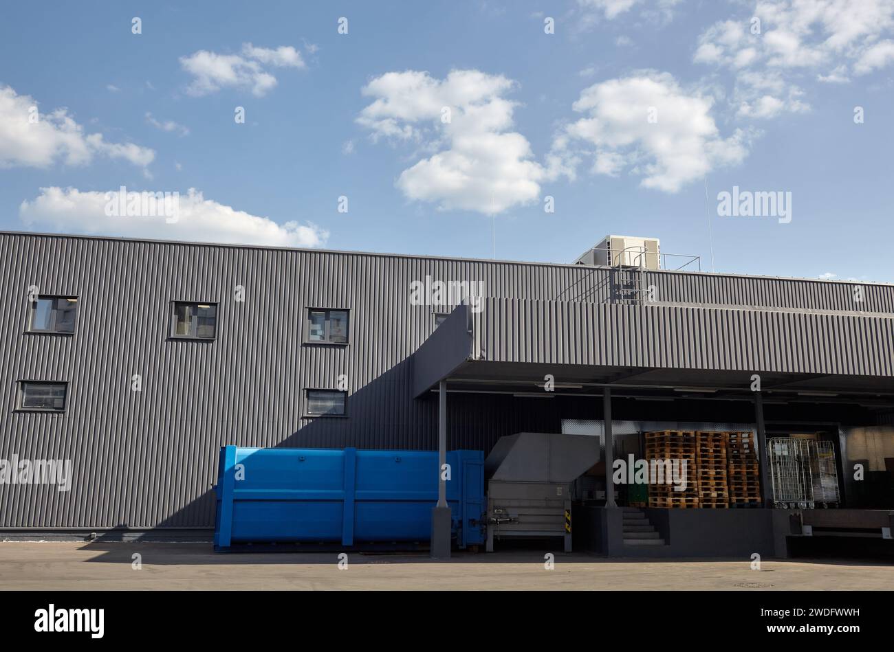 Laderampen eines Lagers. Wellblechlager Industriegebäude vor blauem, klarem Himmel Stockfoto