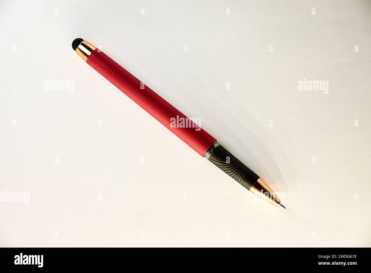 Ein Stift mit seiner Spitze in Rot, Schwarz und Gold auf weißem Hintergrund Stockfoto