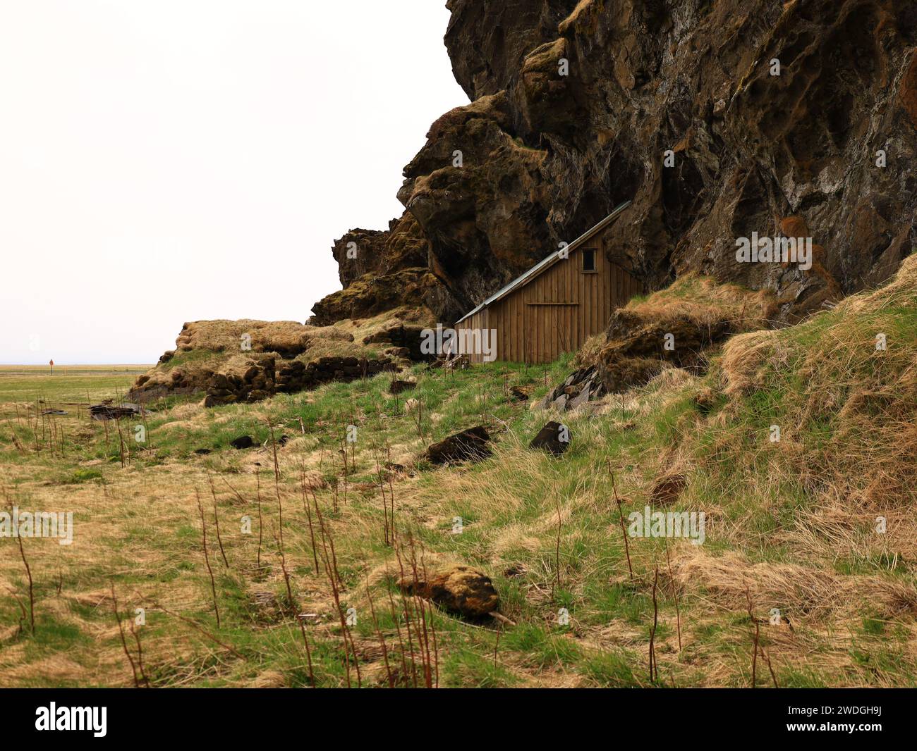 Drangurinn í Drangshlíð ist eine charakteristische Tufffelsenformation, die allein auf dem Weideland der Farm Drangshlíð steht Stockfoto