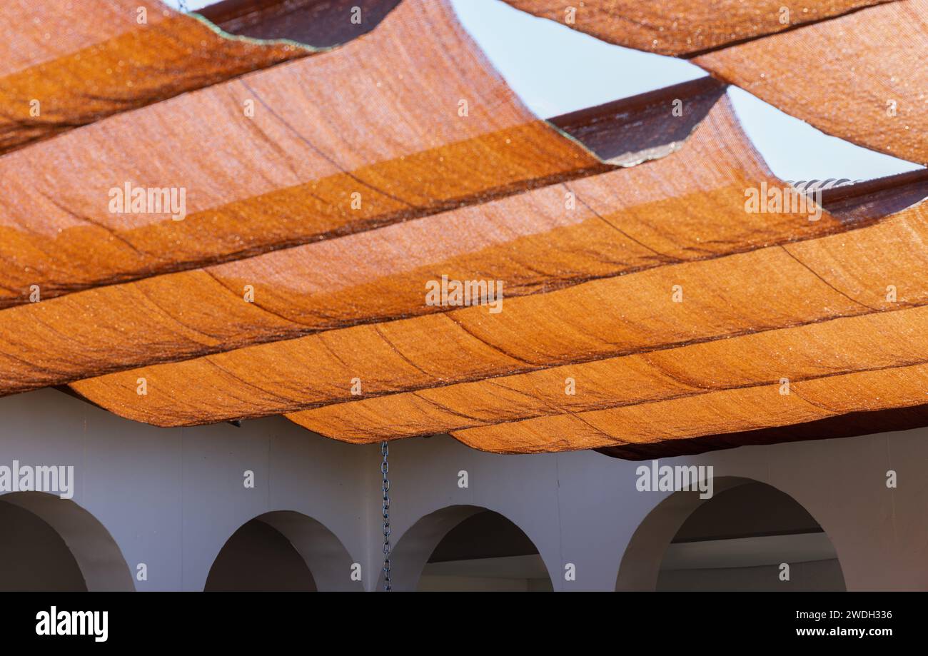 Netzschatten schützen die Gebäudeterrasse vor der heißen Sonne Stockfoto