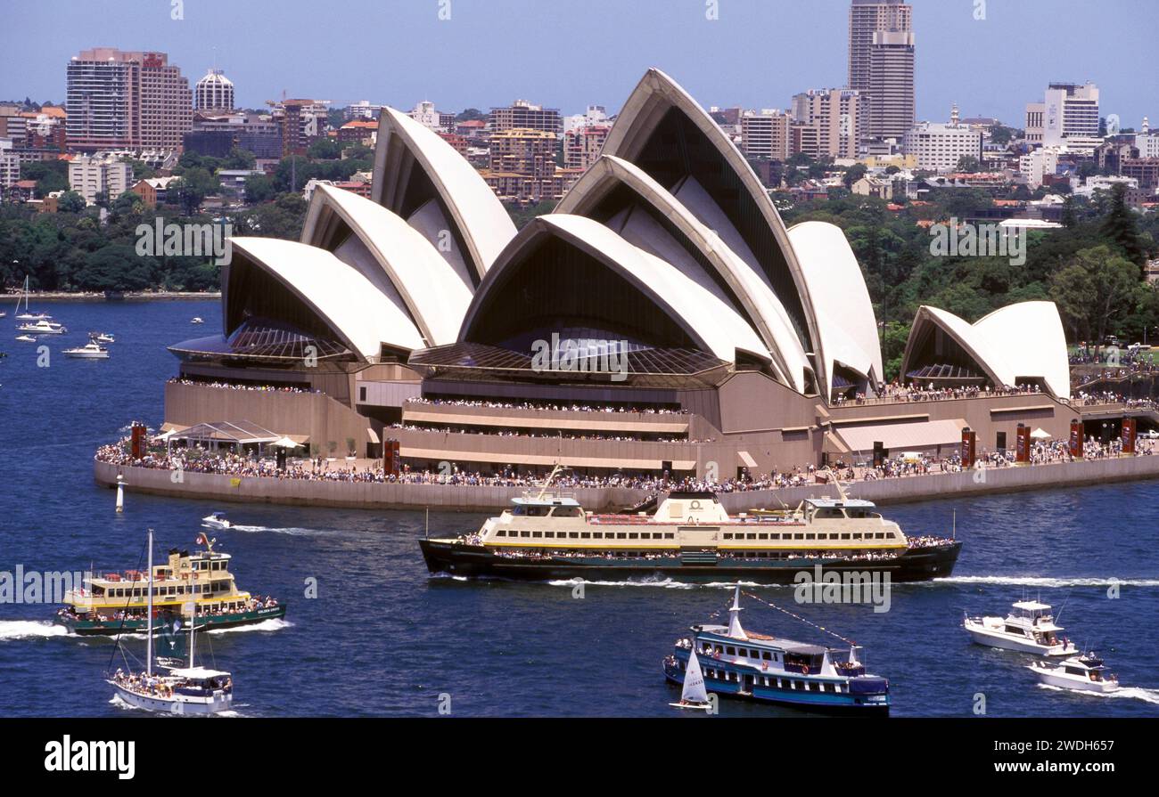 Hafen von Sydney und das Opernhaus von Sydney mit vorbeifahrenden Fähren an einem geschäftigen Wochenende. Stockfoto