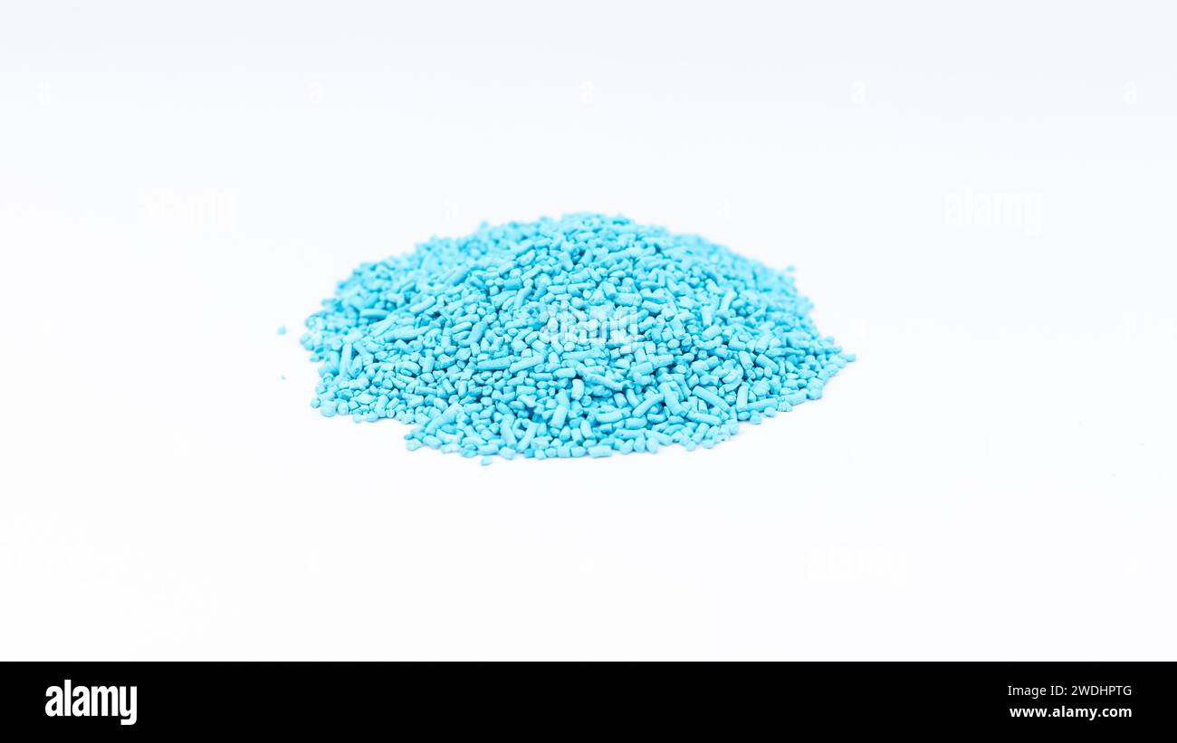 Eisenphosphatblau-Pellets zur Schneckenbekämpfung auf weißem isoliertem Hintergrund Stockfoto