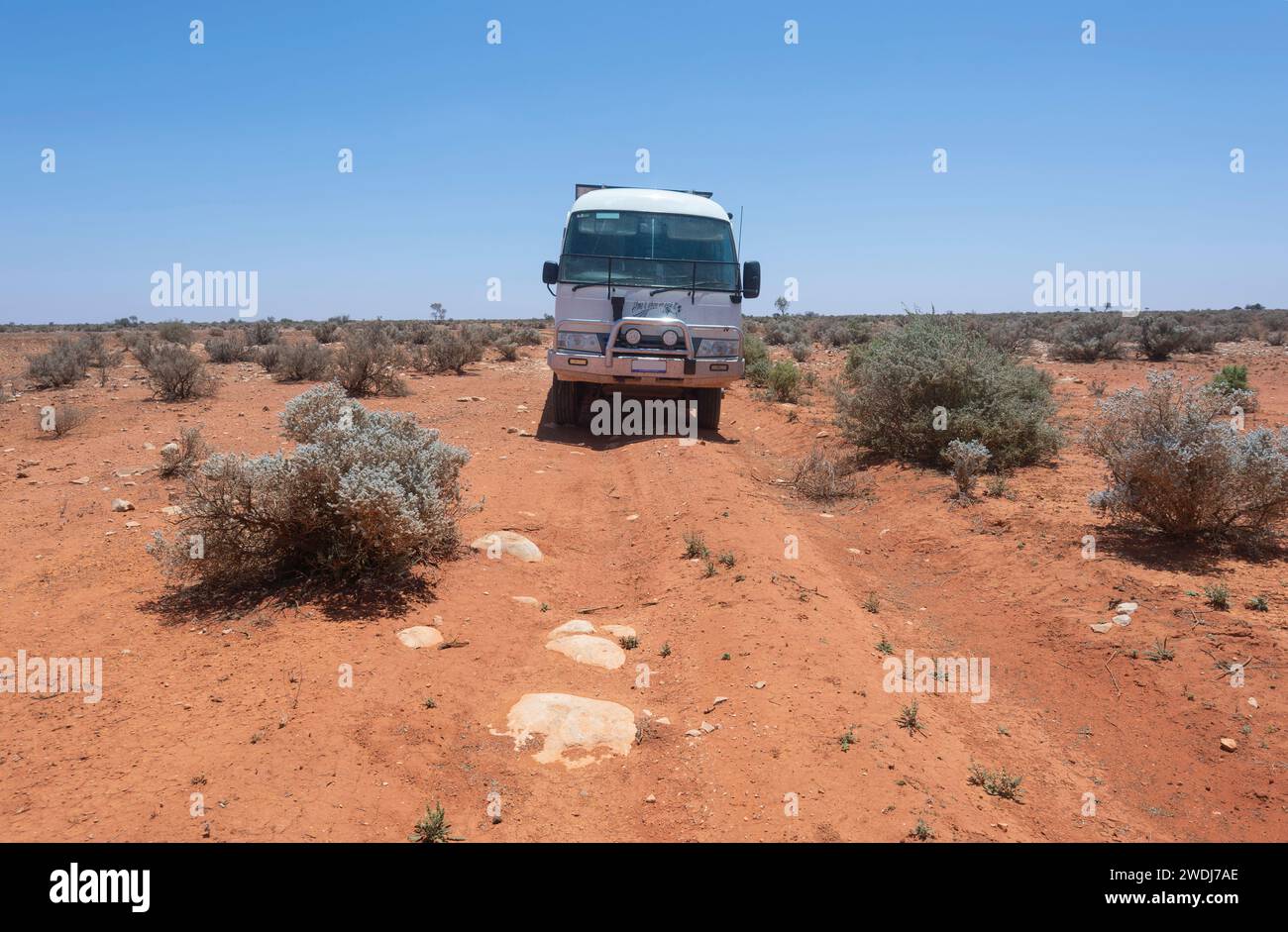 Toyota Coaster mit Allradantrieb auf dem abgelegenen, rauen roten Rawlinna zur Cocklebiddy Outback Road in der Nullarbor Plain, Western Australia, WA, Austra Stockfoto