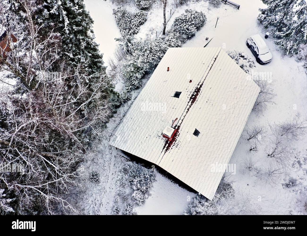 Vertikale Luftaufnahme eines schneebedeckten Einfamilienhausdachs Stockfoto