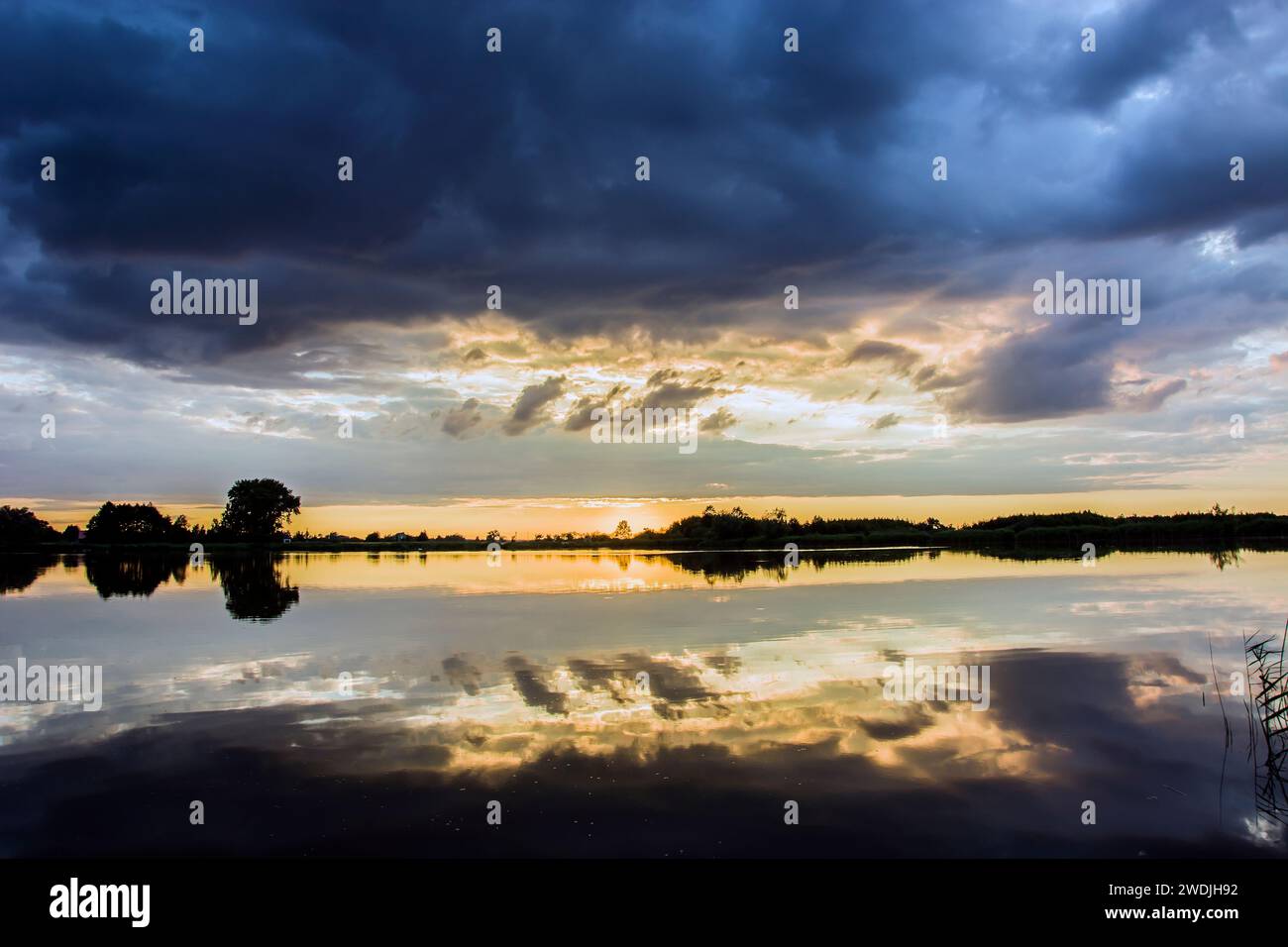 Wolken über einem ruhigen Wassersee, abendlicher Sommer Stockfoto