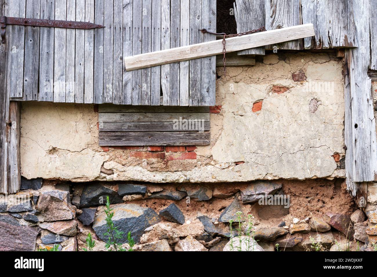 Alte Bauernhausmauer mit Schrankdach und Steinmauer Stockfoto