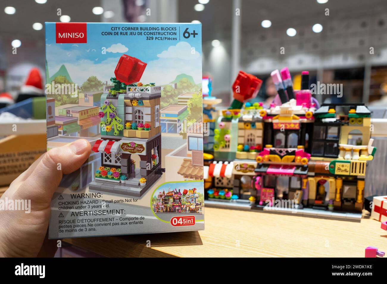 Der Miniso-Markenbauer ist in den Händen des Käufers. Miniso-Produkte in den Regalen des Miniso-Stores. Minsk, Weißrussland - 21. Januar 2024 Stockfoto