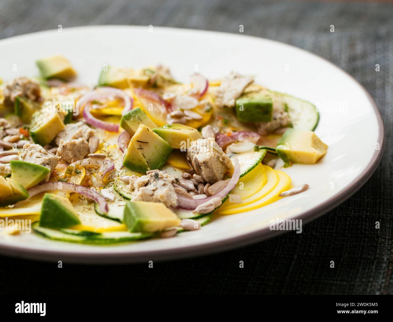 Zucchini-Salat mit hausgemachten veganen Feta-Käse und Avocado. Stockfoto