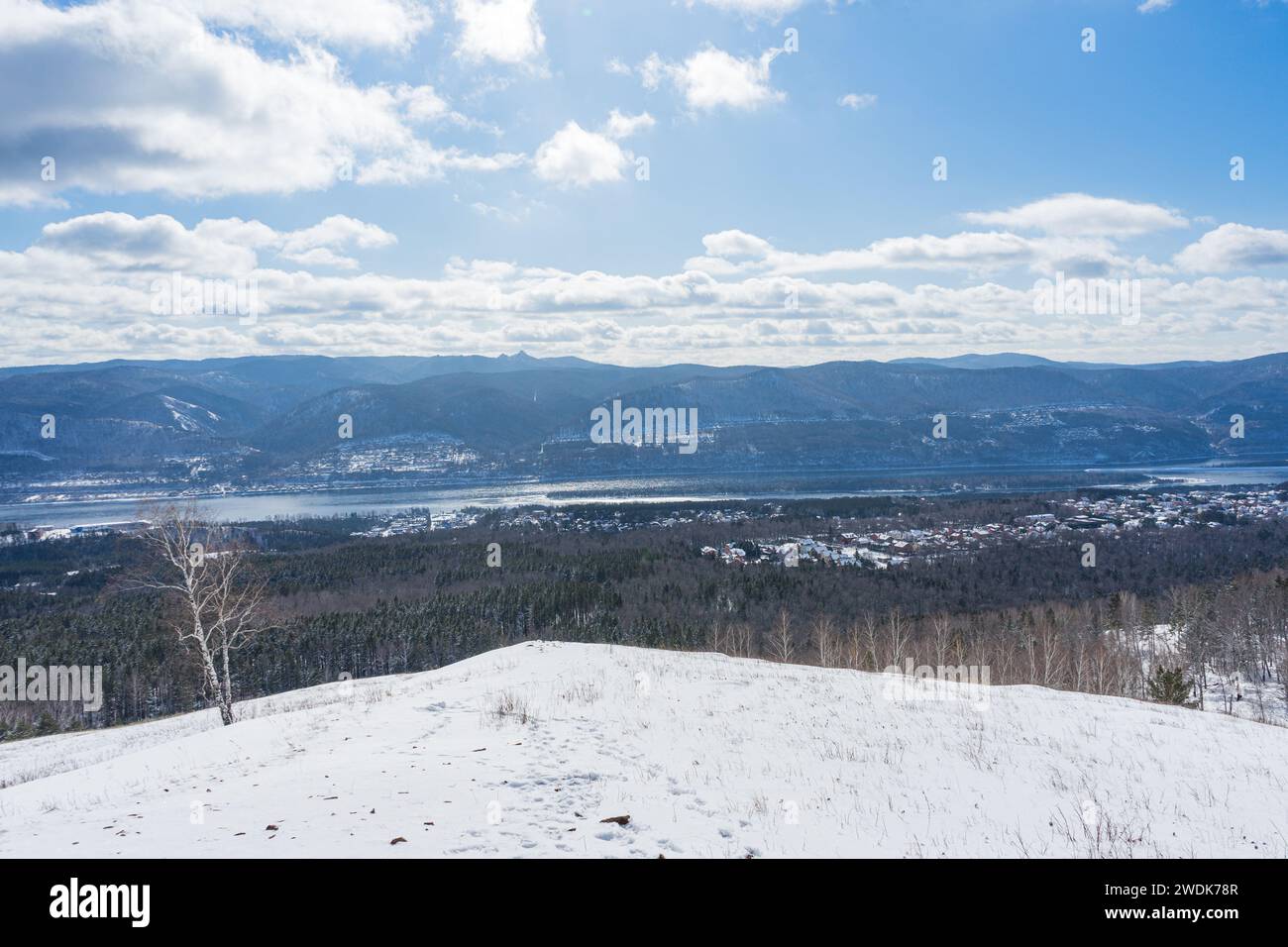 Ungefrorener Fluss Yenisei in Sibirien, friert im Winter nicht ein. Zwei hügelige Ufer eines großen Flusses. Outdoor natürliche Landschaft blauer Himmel mit Wolken, sonnig Stockfoto