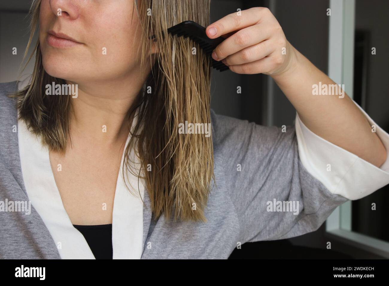 Nahaufnahme einer Frau, die ihr nasses Haar kämmt Stockfoto