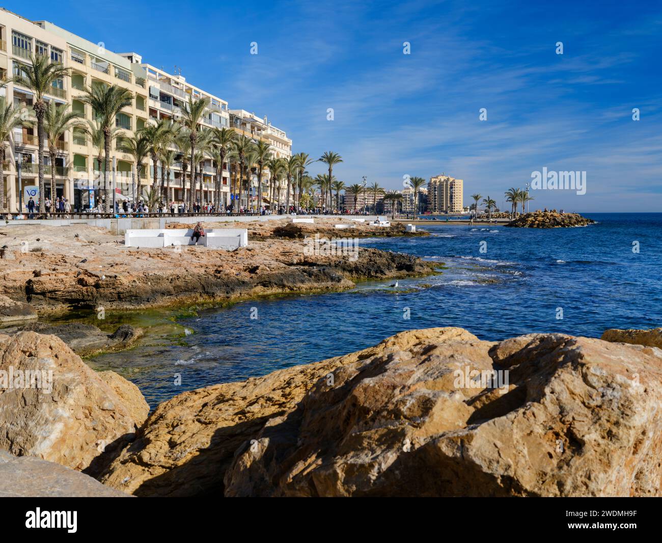 Torrevieja, Alicante, Spanien. Ein wunderschöner Tag Mitte januar an der Küste von Torrevieja, während die Menschen eine sanfte Brise vom Mittelmeer genießen. Stockfoto