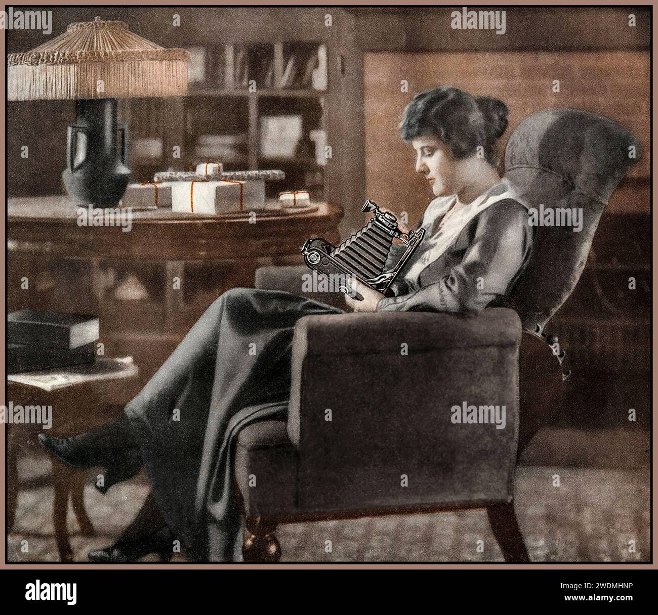 Kodak 1916 Retro-Vintage-Werbespot mit einer Frau in weichem Fokus, die eine Kodak Faltbälge Filmkamera hält, die auf der Rückseite des Country Gentleman Magazine 1900s Photography Camera Eastman Kodak Advertising zu sehen ist. Stockfoto