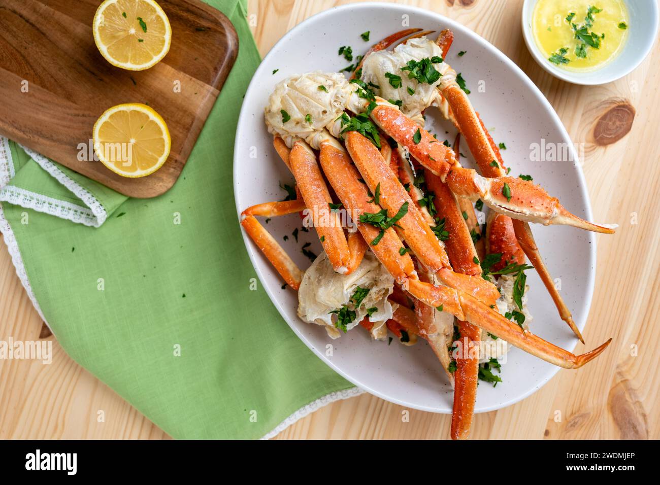Gedämpfte Krabbenbeine mit Knoblauchbutter, Zitrone und Petersilienflocken Stockfoto