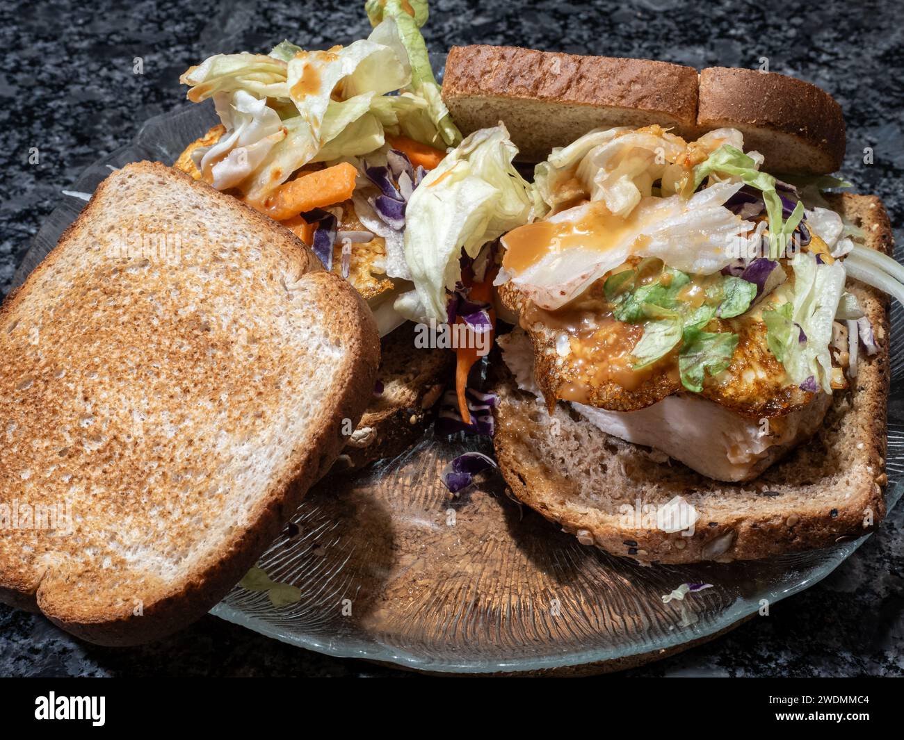 Brunch am Wochenende: Perfekt getoastetes Vollkornbrot, mit einem Hauch von Rauch gewürztes Huhn, goldenes Eigelb, das aus einem knusprigen Ei blickt, und Gier Stockfoto