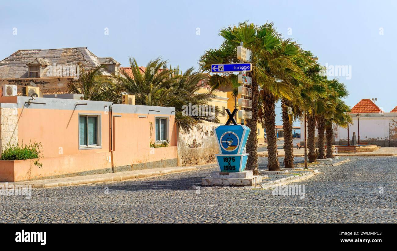 Die kopfsteingepflasterte Straße von Sal Rei, gesäumt von lebhaften Gebäuden und Palmen, lädt Touristen ein, den Charme von Boa Vista zu erkunden. Hochwertige Fotos Stockfoto