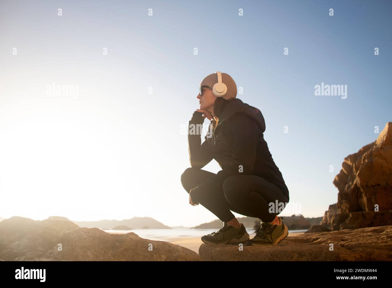 Frau, die ausgeruht ist und die Aussicht genießt, während sie Musik mit Kopfhörern hört. Stockfoto