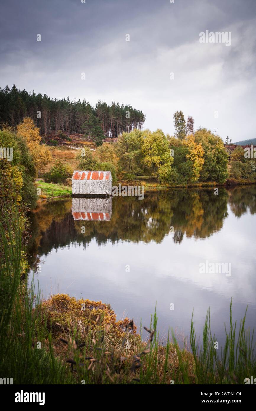 Bootshaus am Rande eines Lochs in schottischer Herbstlandschaft. Loch Laide, Abriachan, Scottish Highlands, Schottland, Großbritannien Stockfoto