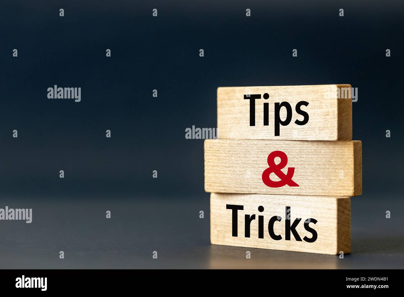 Holzblöcke mit den Worten Tipps und Tricks. Symbol für Tipps und Tricks. Schöner blauer marineblauer Hintergrund. Geschäftskonzept und Unternehmensberatung. Spa kopieren Stockfoto