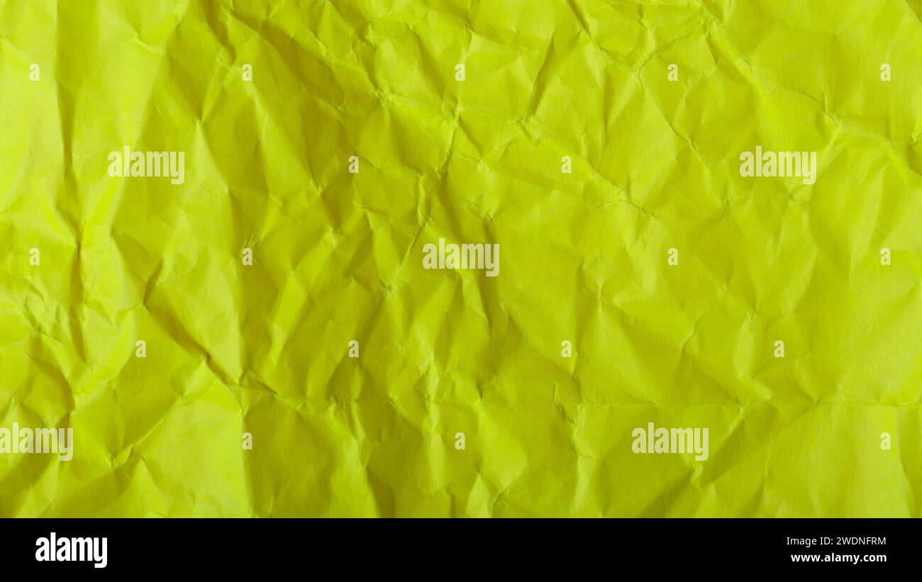 Hintergrund aus zerknittertem gelbem Grünpapier, strukturiertes Farbpapier mit Falten Stockfoto