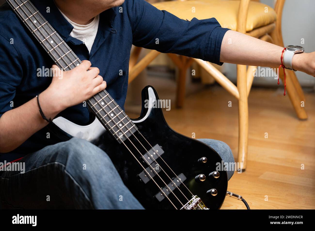 lateinischer Mann lernt, E-Bass zu spielen und den Bass zu halten Stockfoto