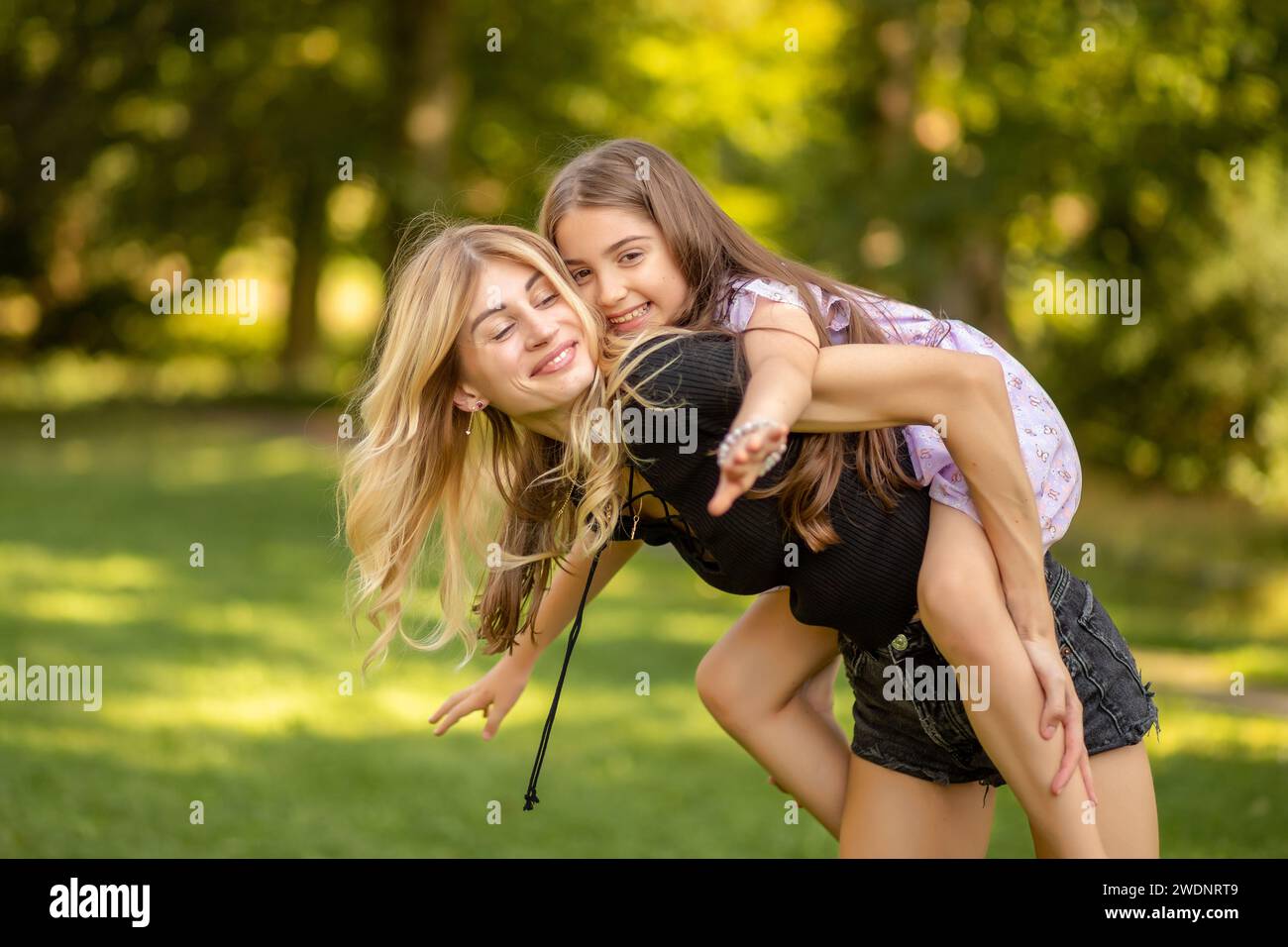 Mutter und Tochter spielen, Tochter Huckepack. Stockfoto