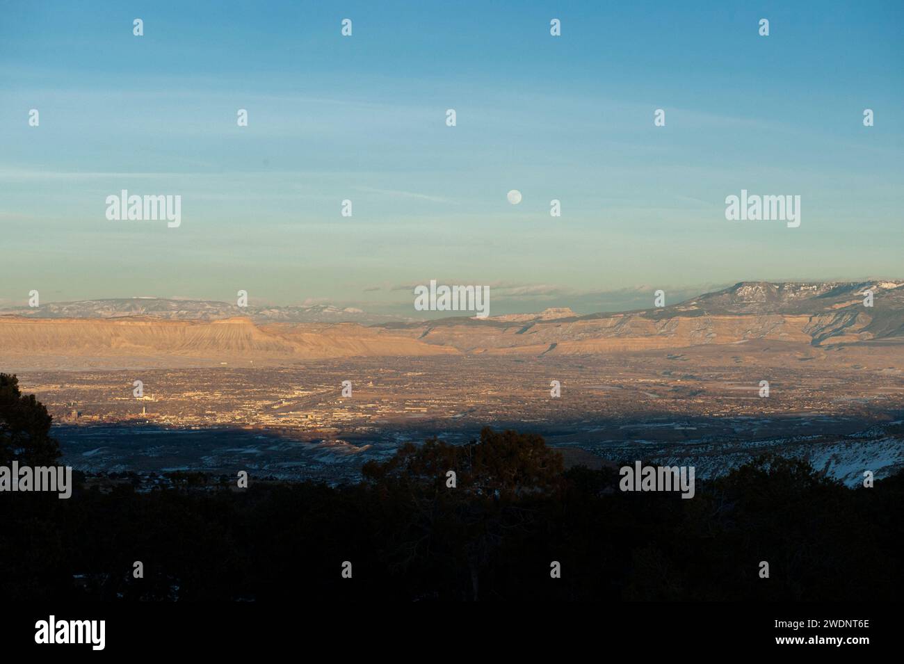 Ein Vollmond im Januar steigt über der Stadt Grand Junction, Colorado. Stockfoto