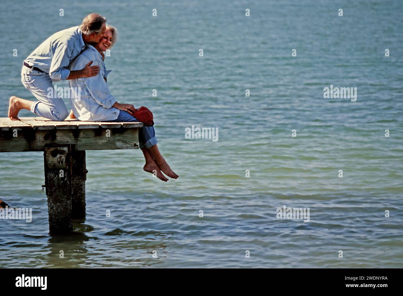 Ein älteres Paar, das einen romantischen Moment auf dem Dock mit Blick auf den Atlantik in Südflorida im Urlaub hat Stockfoto
