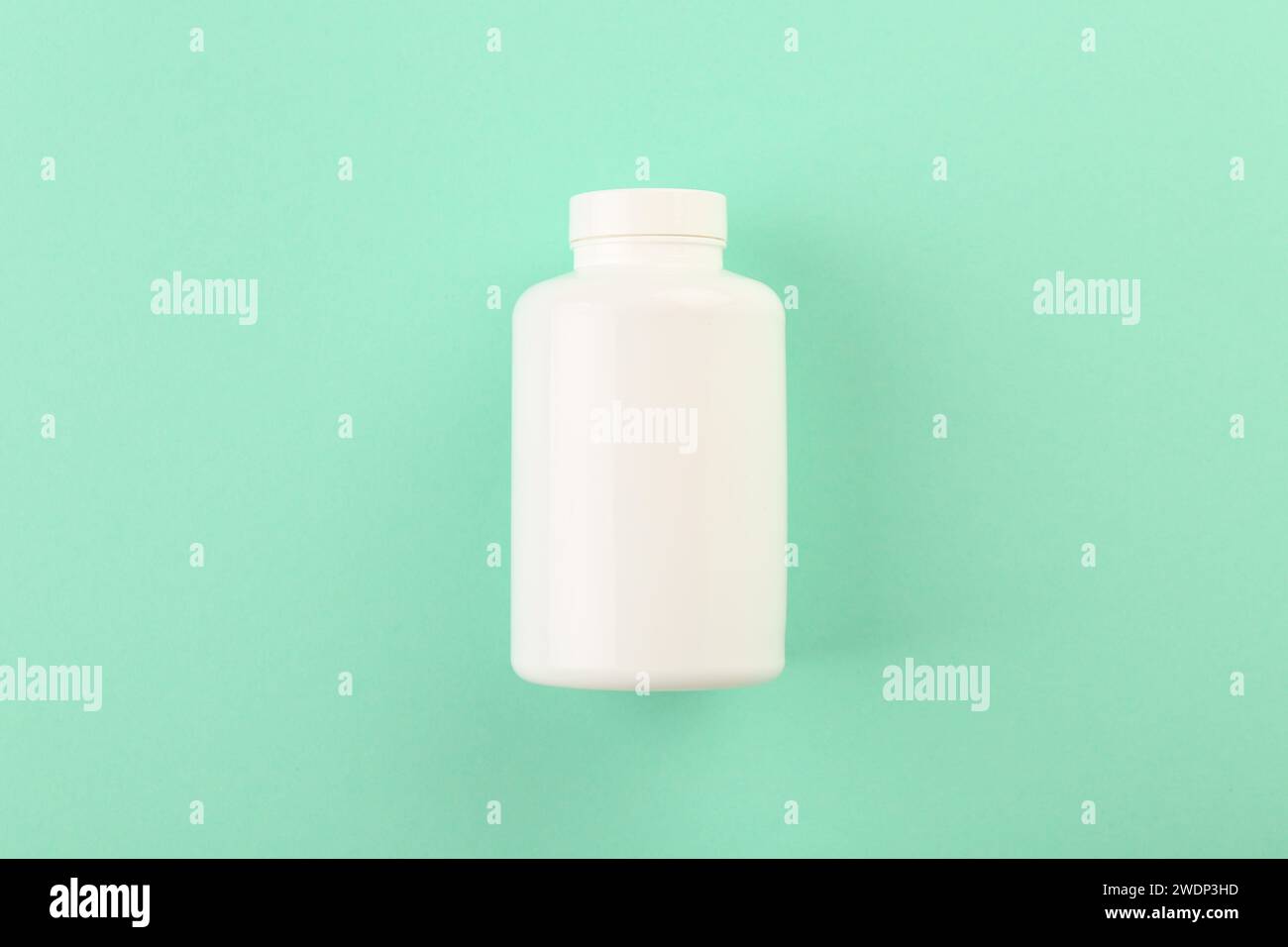 Leere weiße Pillenflasche auf türkisfarbenem Hintergrund, Draufsicht. Leerzeichen für Text Stockfoto