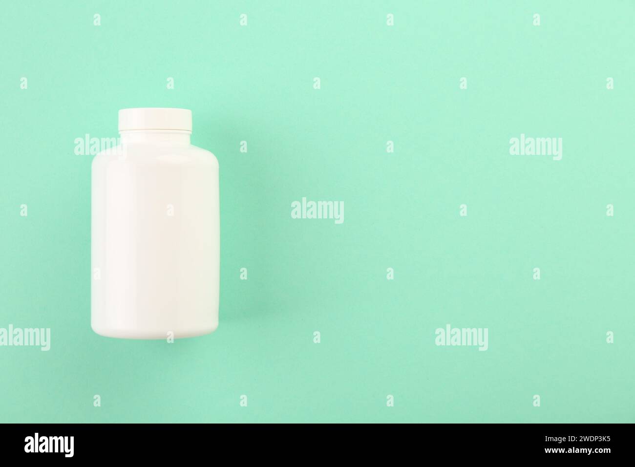 Leere weiße Pillenflasche auf türkisfarbenem Hintergrund, Draufsicht. Leerzeichen für Text Stockfoto