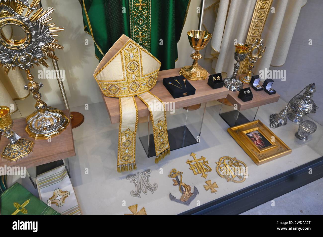 Katholische religiöse Gegenstände (Gehrungshüte, Tassen, Manschettenknöpfe, Abzeichen usw.) in einem Schaufenster – Rom, Italien. Oktober 31 2022 Stockfoto