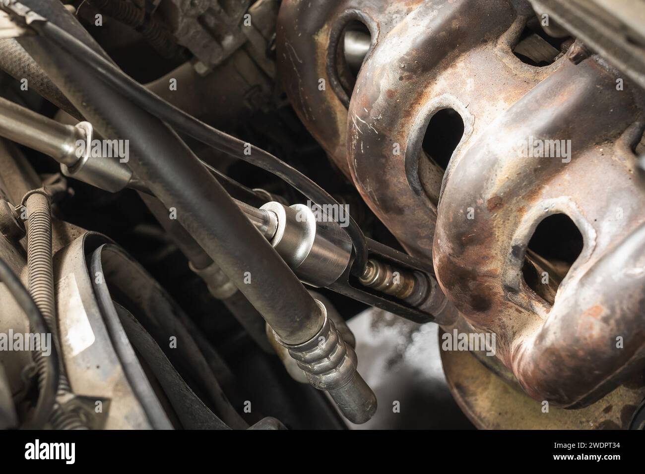 Der Arbeitsablauf, einen Autosauerstoffsensor an einem Automotor zu Schrauben, Nahaufnahme Stockfoto