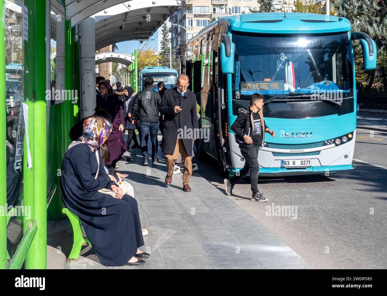 Öffentliche Verkehrsmittel in Sanliurfa Türkei: Bushaltestelle in Sanliurfa, Leute, die auf einen Bus warten Stockfoto