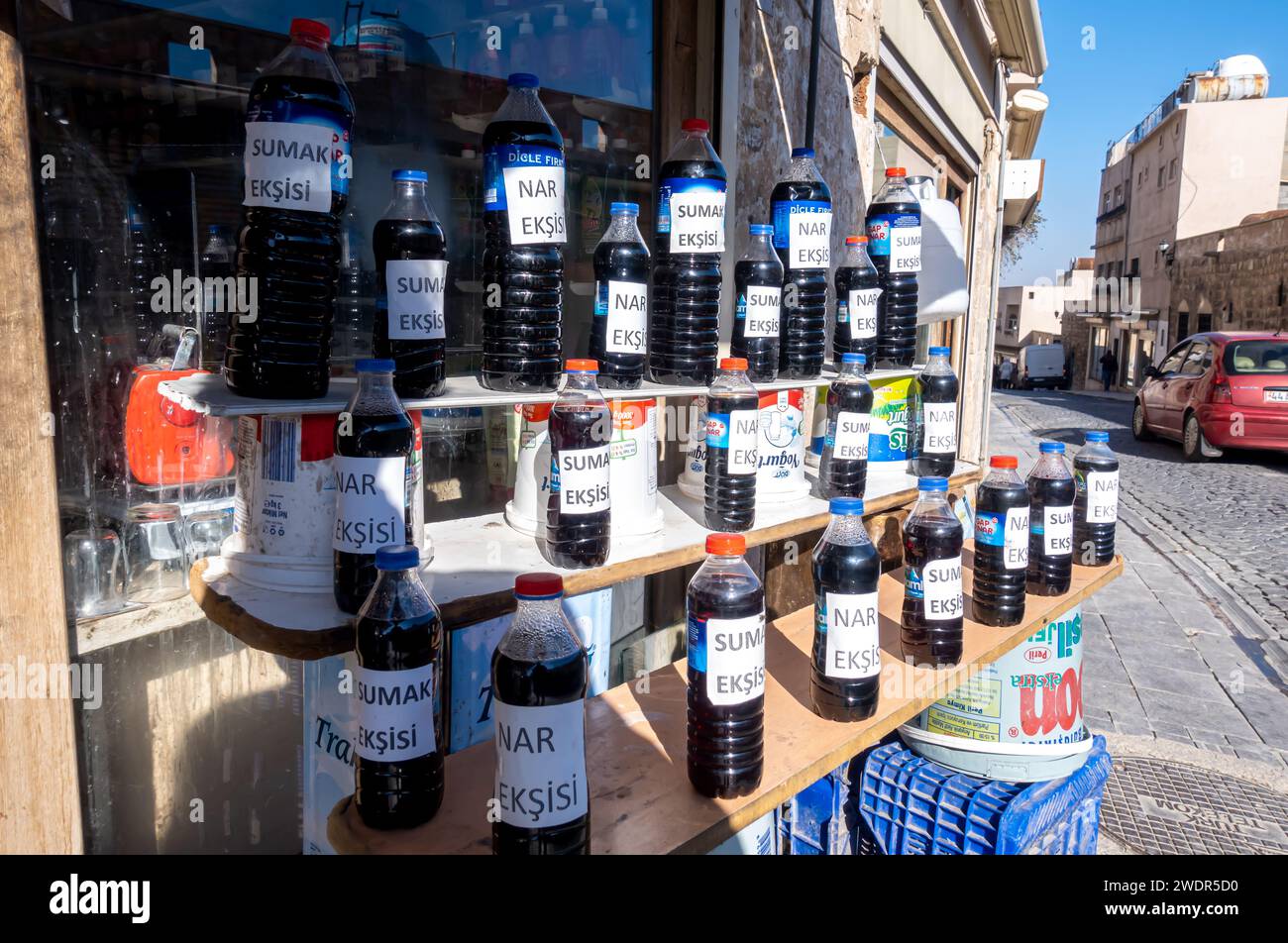 Hausgemachtes Granatapfelkonzentrat, das in Plastikflaschen in den Straßen von Mardin Türkei verkauft wird, lokale Landwirte, die Produkte verkaufen Stockfoto