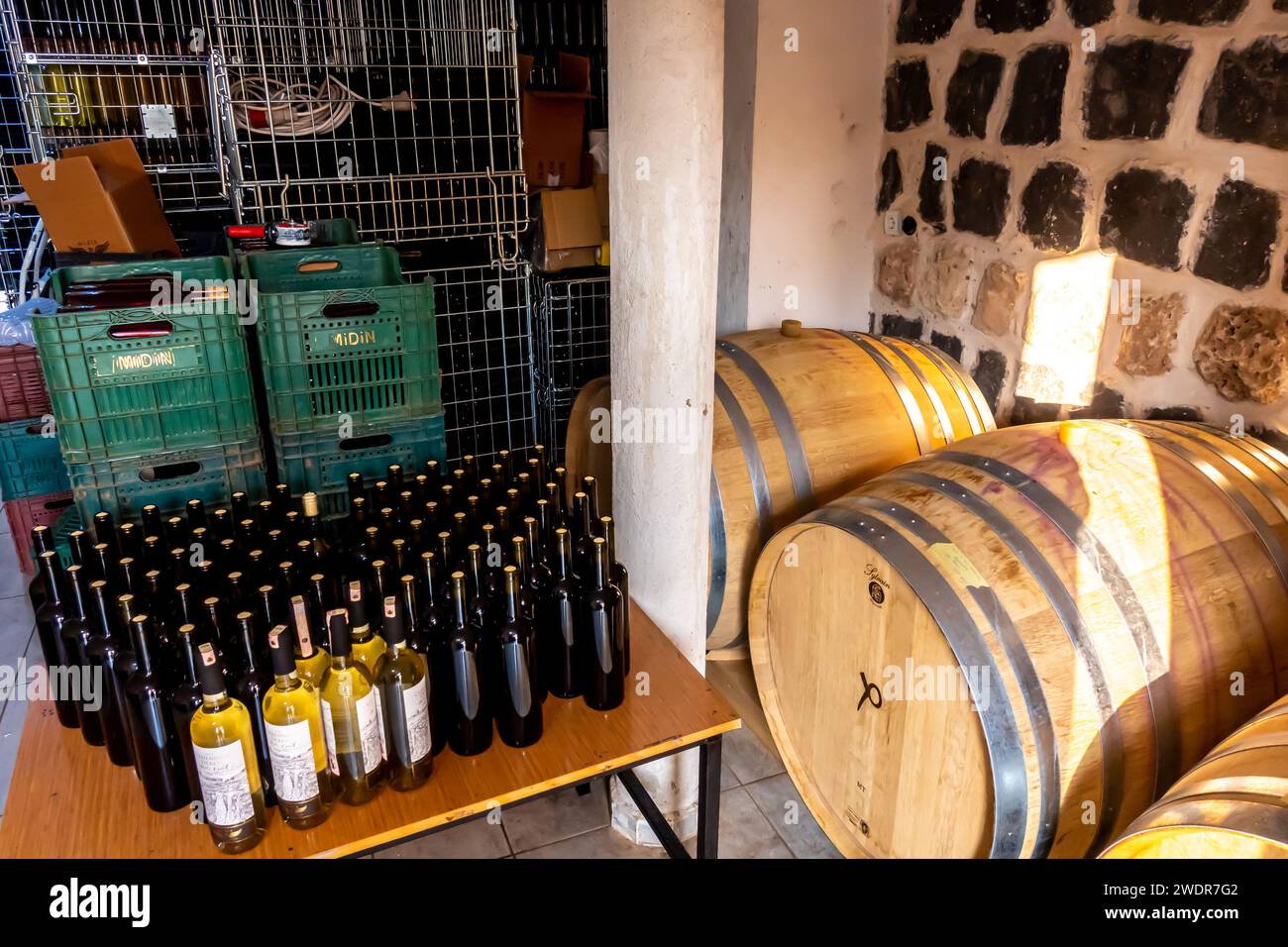 Fässer mit Wein und Flaschen mit hergestelltem Wein in einer Weinherstellung in der Weinkellerei Midin Şarapçılık im Südosten der Türkei Stockfoto