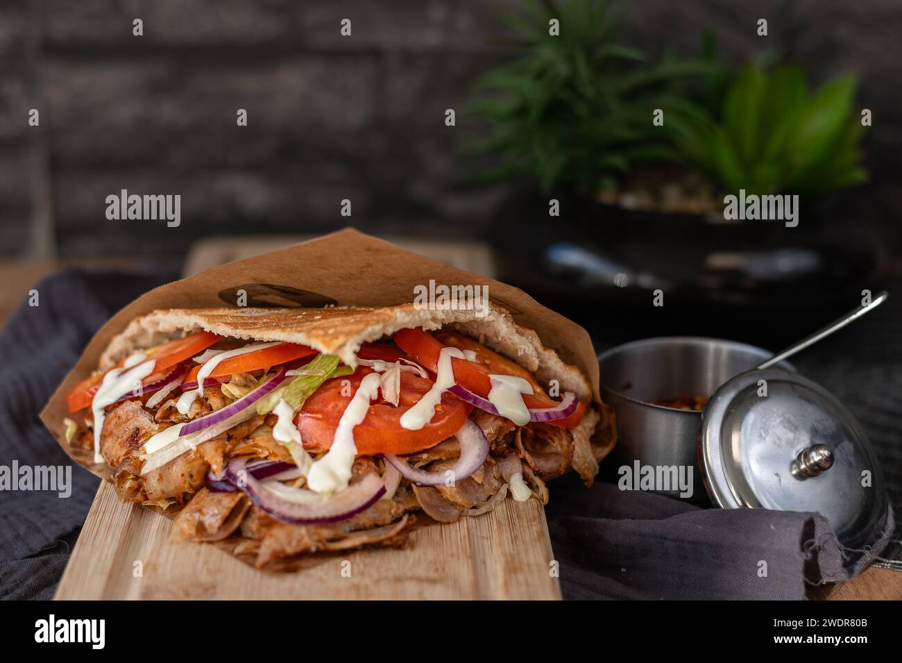 Ein türkischer Döner mit Hühnerfleisch auf einem Holzbrett. Stockfoto