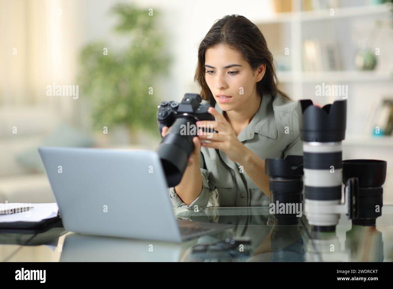 Interessierter Fotograf, der zu Hause eine spiegellose Kamera überprüft Stockfoto