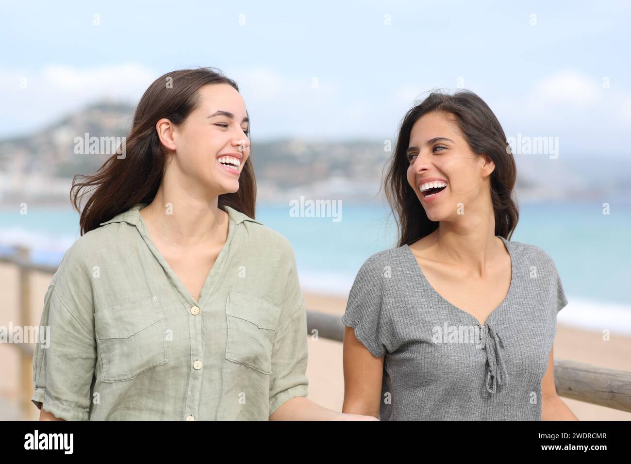 Glückliche Frauen, die am Strand reden und laufen Stockfoto