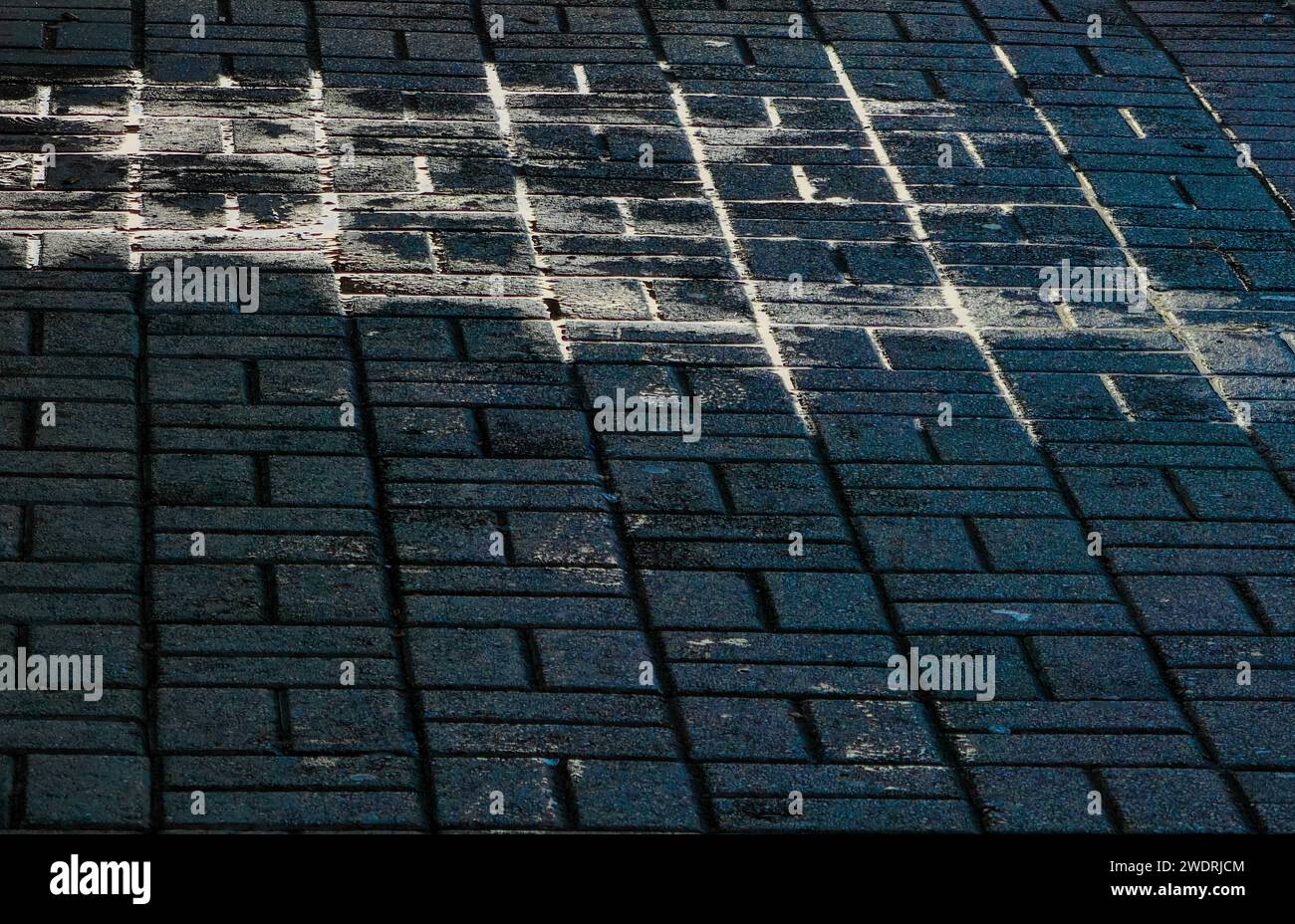 Abstraktes Leuchten, auf dem Straßenboden. Stein gefrorene Oberfläche. Muster und Textur. Stockfoto