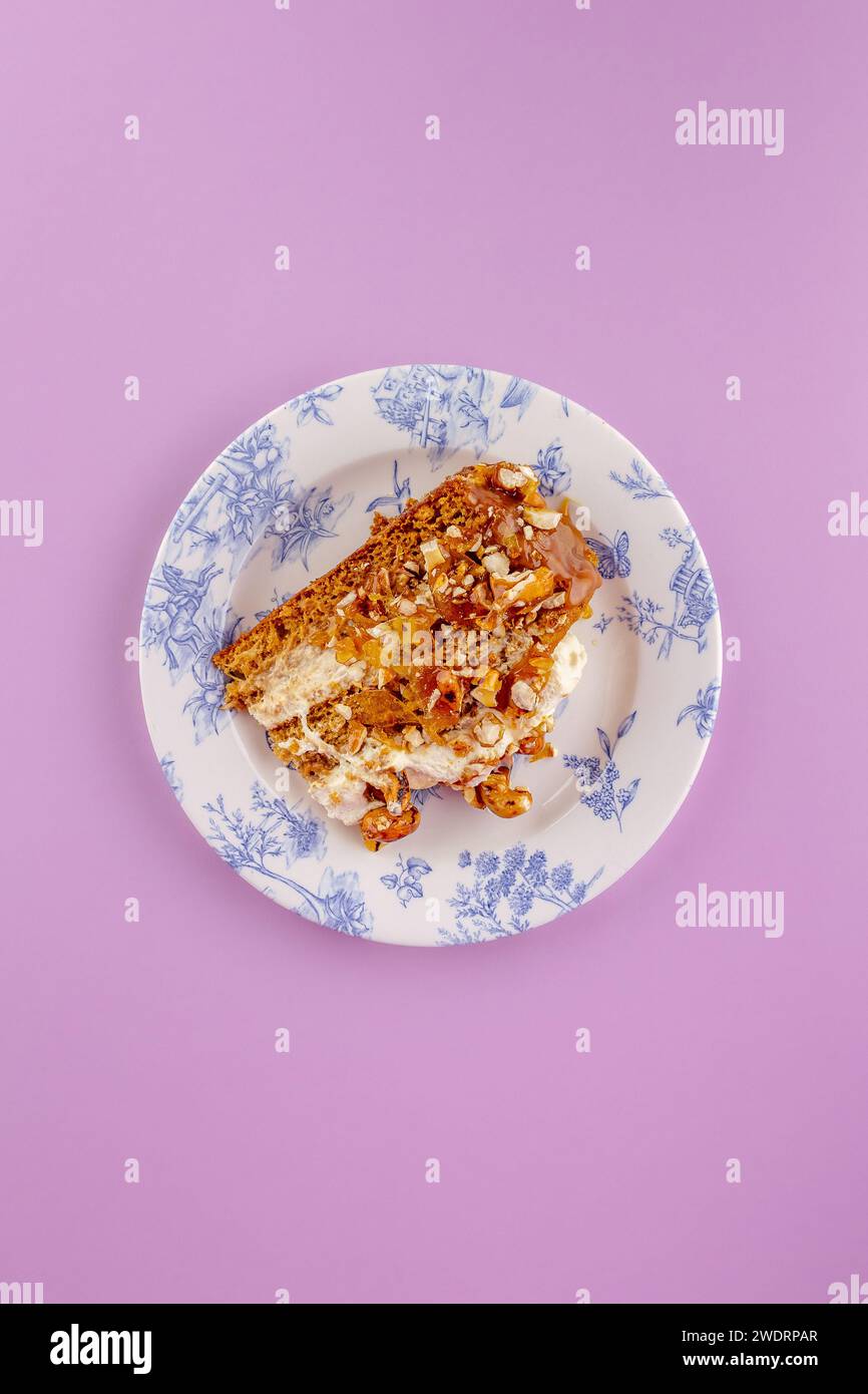 Biskuitkuchen mit Sahne und Nüssen auf gelbem Hintergrund Stockfoto