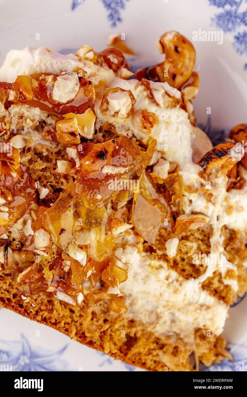 Biskuitkuchen mit Sahne und Nüssen auf gelbem Hintergrund Stockfoto