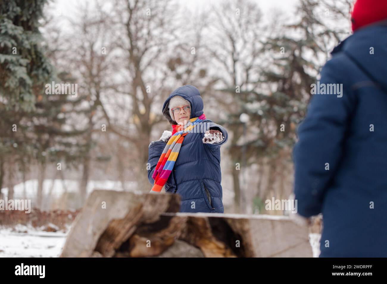 Kinder werfen Schneebälle in den Park Stockfoto