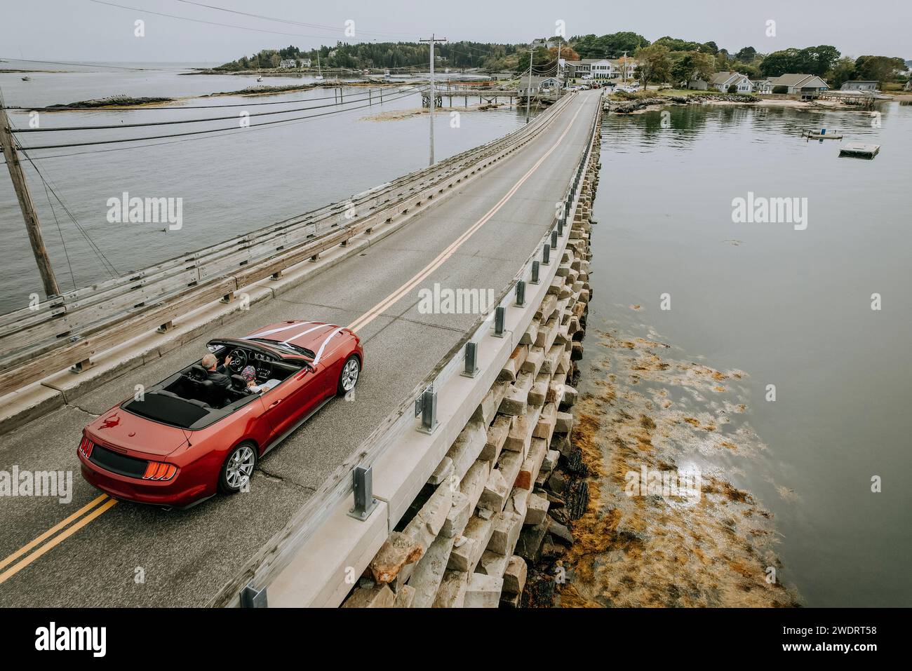 Rotes Cabriolet mit oben unten überquerender Brücke nach Harpswell, Maine Stockfoto