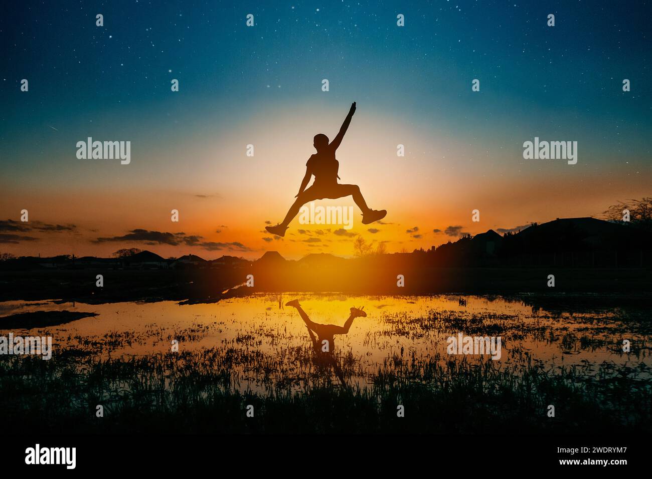 Silhouette eines Mädchens, das in die Luft springt, mit Sternen hinter ihr Stockfoto