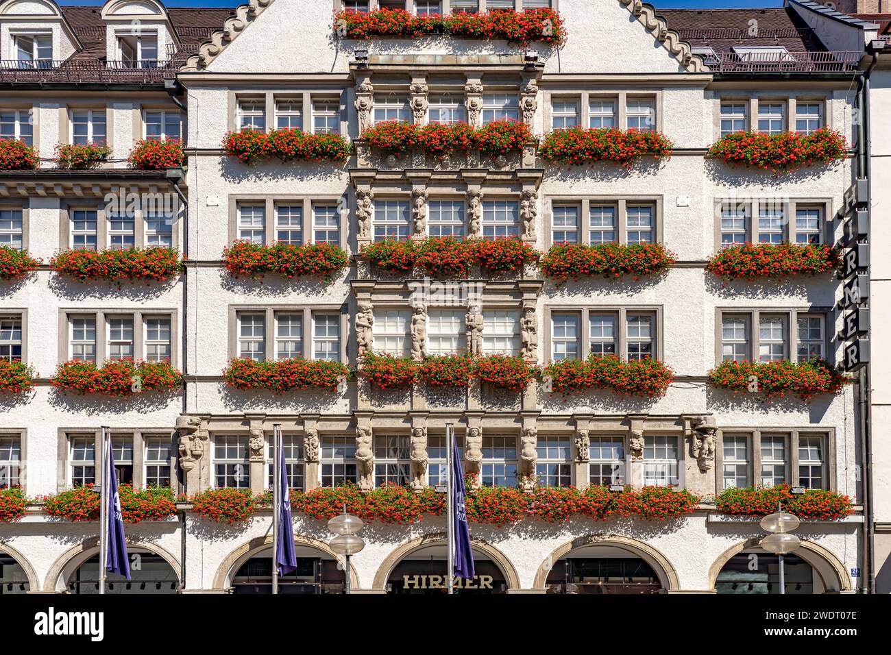 Blumenschmuck an der Fassade des Bekleidungsgeschäfts Hirmer in München, Bayern, Deutschland, Europa | Blumenschmuck des Hirmer Fashion Store Stockfoto