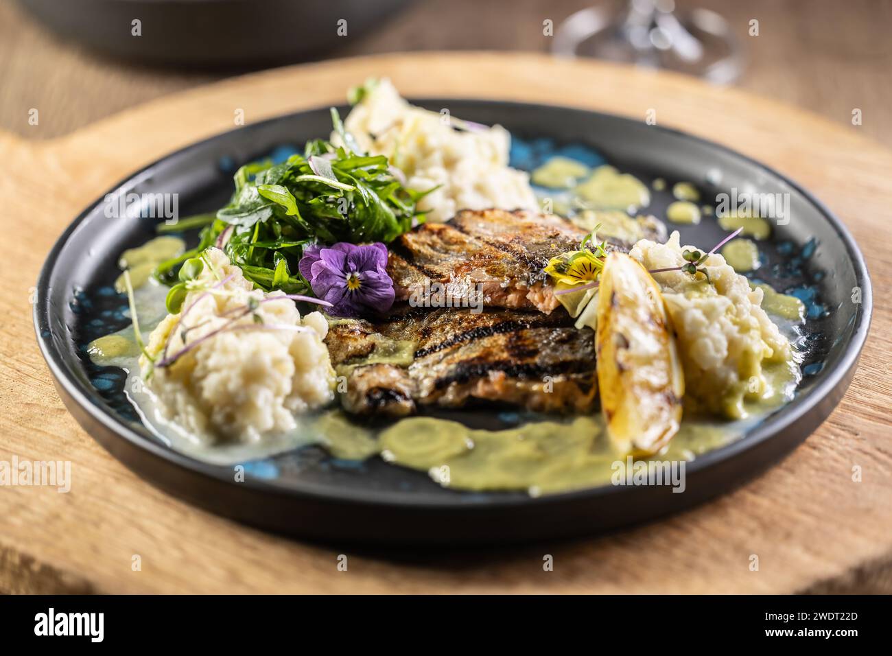 Gegrilltes Forellenfilet mit Kartoffelpüree und Zitronensauce auf einem Restaurantteller. Stockfoto