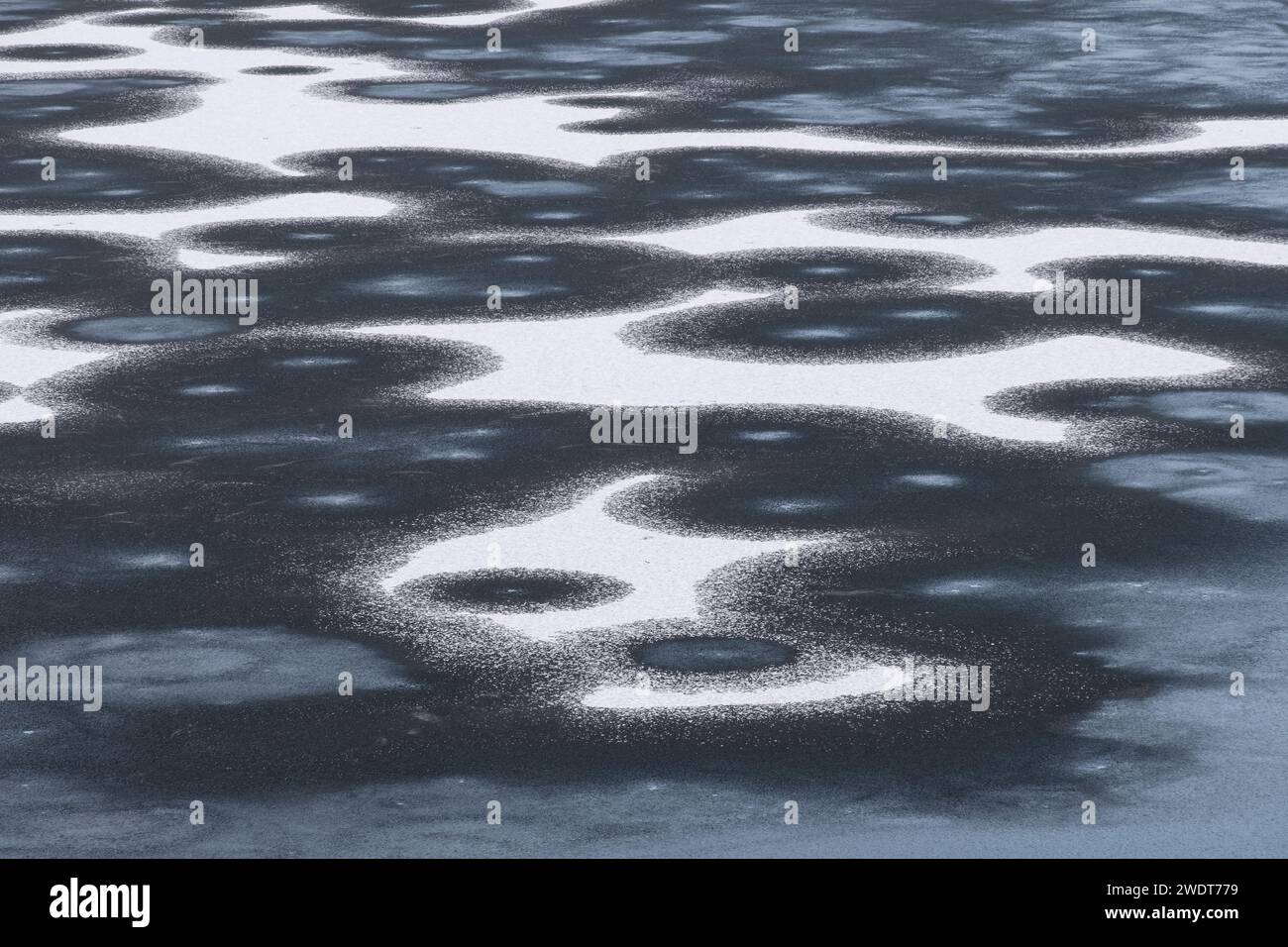 Eismuster auf dem gefrorenen Llyn y Dywarchen im Winter, Snowdonia-Nationalpark (Eryri), Nordwales, Vereinigtes Königreich, Europa Stockfoto